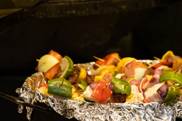 Blurred image of a tray full of skewers with various vegetables