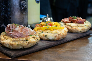 Three savory muffins with different toppings, some of which are out of focus