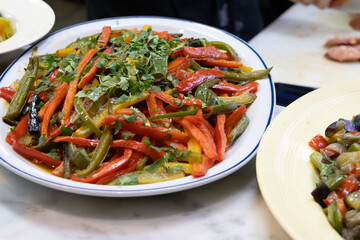 A generous portion of various vegetable strips, including carrots, green peppers, and red peppers. Everything is topped with chopped fresh parsley