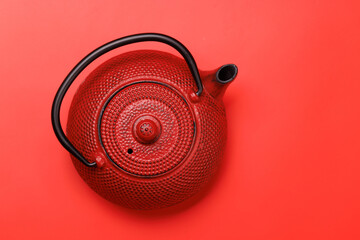 Red teapot on a red background, top view