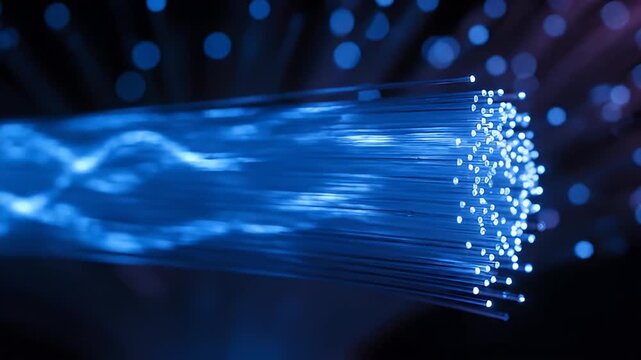 Close-up of a bundle of glowing blue fiber optic strands transmitting data with shimmering light effects against a dark blurred background ideal for
