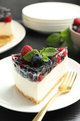 Piece of delicious cheesecake with berries and mint on table, closeup