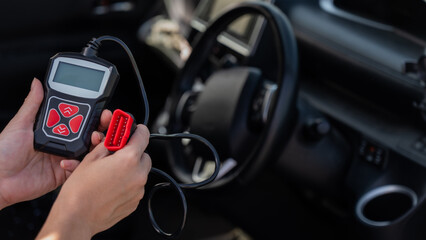 Woman using OBD2 diagnostic scanner. 