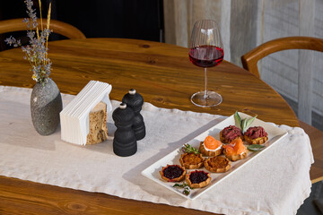An Elegant Dining Table Set with Gourmet Appetizers, Fine Wine, and Beautiful Decor