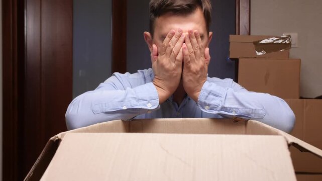 Man feeling disappointed looking into empty cardboard box