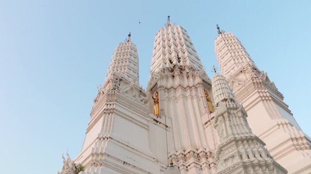 White Thai Chedi Towers with Golden Buddha Statues at Mahathat temple Thailand.