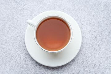 Aromatic black tea in cup on light grey table, top view