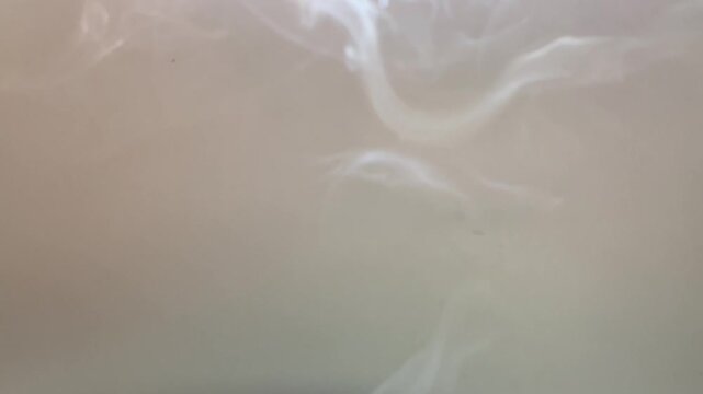 White smoke billowing isolated on a grayish white background.