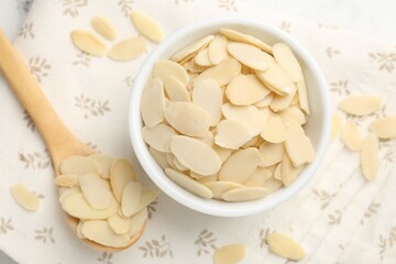 Fresh almond flakes on white table, top view