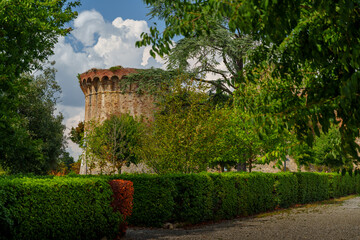 Medieval Fortress Tower surrounded by Lush Greenery, San Gimignano Tuscany, Summer Landscaping Scene