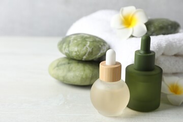 Beautiful spa composition with essential oils on light table, closeup. Space for text