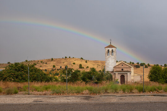 Landscape with the church of Santa Julita and a rainbow in the background in Barcience, Toledo province, Spain