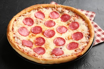 Delicious pepperoni pizza on black background, closeup