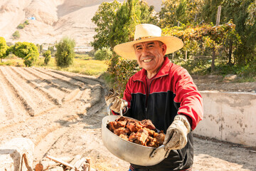 A man from the countryside prepares pork cracklings in a traditional kitchen.