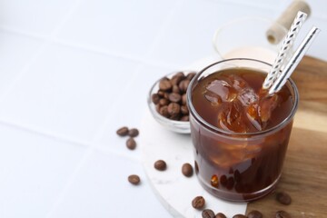 Tasty iced coffee, milk and beans on white table, closeup. Space for text