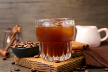 Tasty iced coffee and beans on wooden table, closeup