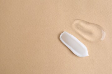 Samples of cosmetic products on beige background, top view. Space for text