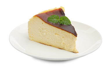 Piece of delicious Basque cheesecake with mint isolated on white