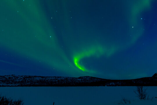 Leuchtende Nordlichter. Gr&uuml;n-violette Aurora Borealis tanzt &uuml;ber Landschaft und Himmel.