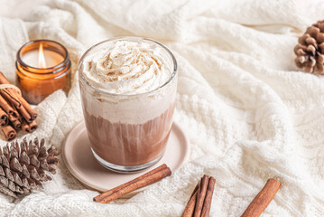 Cozy winter or Christmas concept with coffee (Eggnog Latte) and candle