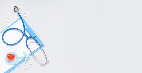 Stethoscope, clipboard, heart, pills and male symbol on light background with space for text