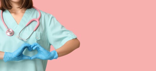 Female cardiologist with stethoscope showing heart gesture on pink background with space for text