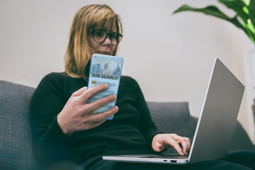 Woman uses her phone and laptop to search for jobs online. Modern job search process. Use of technology and web platforms for finding new career opportunities. Job hunting, career, recruitment concept