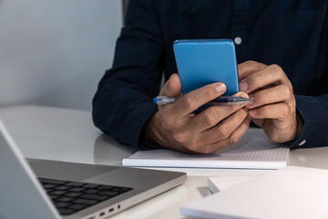 Professional simultaneously operating laptop and smartphone, highlighting multitasking and digital connectivity in modern work