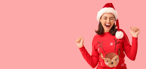 Beautiful happy young woman in pajamas and Santa hat on pink background