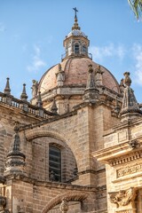 Fototapeta premium The dome and statues of Jerez Cathedral in Cadiz, Spain, illuminated by sunlight against a clear blue sky