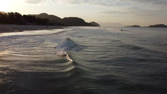 Beautiful sunrise on a tropical paradise beach with small waves in Juquehy