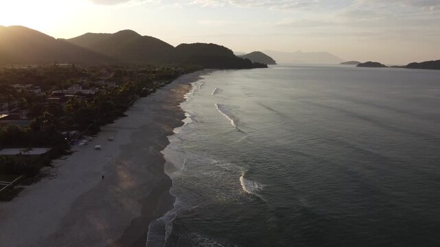 Beautiful sunrise on a tropical paradise beach with small waves in Juquehy