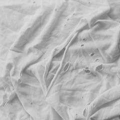 A worn t-shirt with holes. Black and white. Close up.