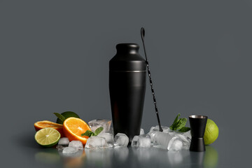 Bartender utensils with ice cubes, citrus fruits and mint leaves on table against grey wall
