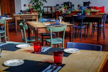Close-up dining table with blue glasses, red pepper grinder, and wildflower bouquet