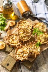 Rustic mushroom tartlets on wooden cutting board perfect for  appetizers.