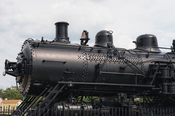 A vintage steam train on display in a city park.