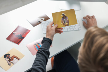 Professional photographer working with photos at white table, above view