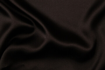 Elegant black satin silk fabric material with subtle draperies. Top view