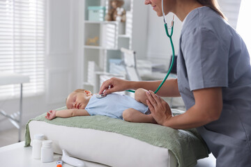 Obraz premium Doctor examining cute little child with stethoscope in hospital, closeup. Checking baby's health