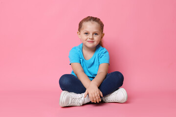 Naklejka premium Cute little girl posing on pink background