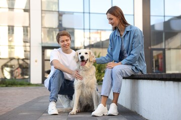 Couple with their adorable golden retriever dog in on city street