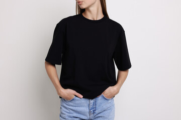 Obraz premium Woman wearing black t-shirt on white background, closeup. Mockup for design