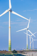 Fototapeta premium White wind turbines stand on the coast