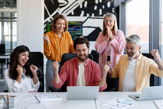 Diverse business team celebrating achievement in office