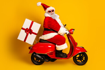 Santa Claus riding a red scooter with a gift on a bright yellow background spreading Christmas cheer and holiday joy