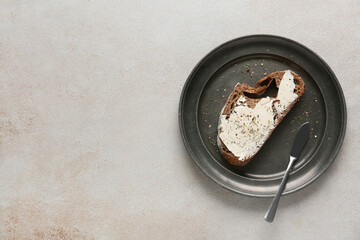 Slice of fresh bread with butter and herbs on grey grunge background