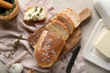 Sliced bread with butter, garlic and thyme on light background