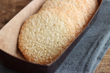 Sesame cookies in a box on a wooden table