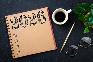 New year goals 2026 on desk. 2026 resolutions list with notebook, plant on black table. Resolutions, plan, goals, action, checklist, idea concept. New Year 2026 resolutions, copy space